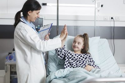 Doctor doing high five with patient in hospital