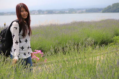 Portrait of young woman standing on field
