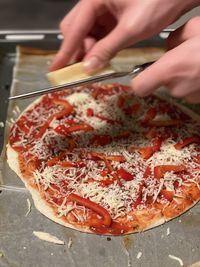 Close-up of hand holding pizza