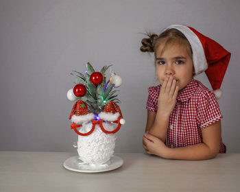 Portrait of young woman sitting on table