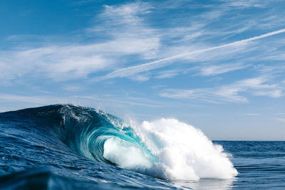 Sea waves splashing against blue sky