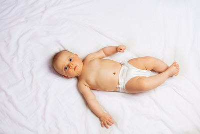 High angle view of cute baby boy lying on bed