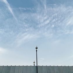 Low angle view of cross on roof against sky