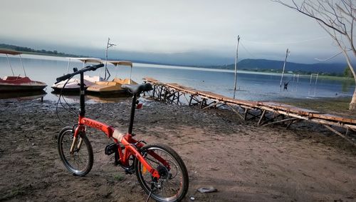 Bicycles parked at beach against sky