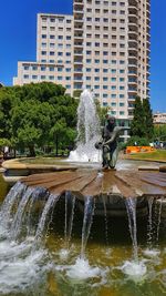 Water splashing in fountain against buildings in city