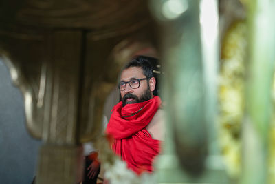 Mature man wearing traditional clothing standing in temple