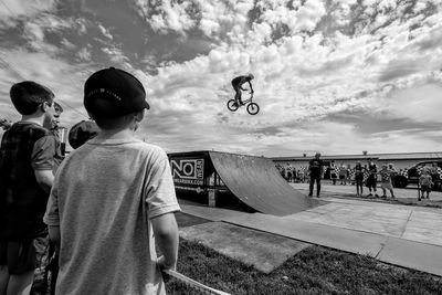 Rear view of people on skateboard against sky