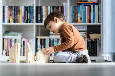 Full length of boy sitting on book