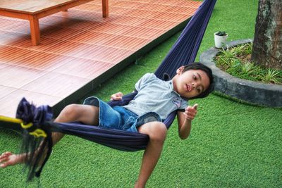 High angle view of siblings lying on grass