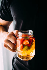 Close-up of hand holding healthy drink in jar