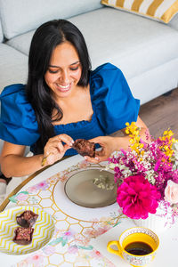 Portrait of young woman sitting on sofa at home