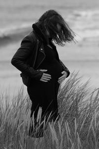 Pregnant woman standing at beach