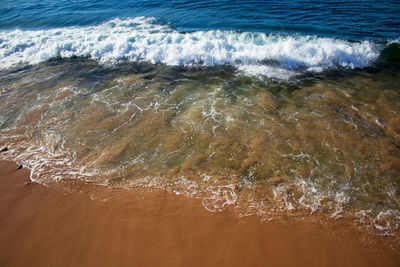 High angle view of waves rushing towards shore