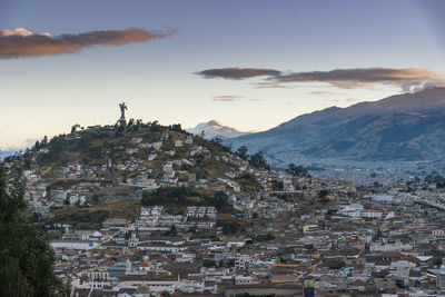 Aerial view of townscape and mountains against sky