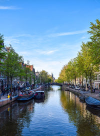 View of canal in city against sky