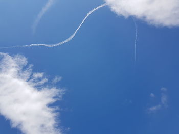 Low angle view of vapor trail against blue sky