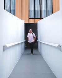 Portrait of man standing against door of building 