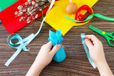 Cropped hand of woman holding decoration on table