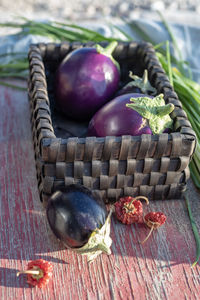 Still life with basket, eggplants, garlic chives, dried red peppers