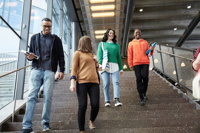 Male and female students walking down steps in university