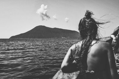 Rear view of woman in sea against sky