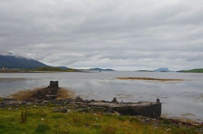 Scenic view of calm lake against cloudy sky