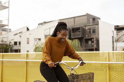 Smiling young woman cycling