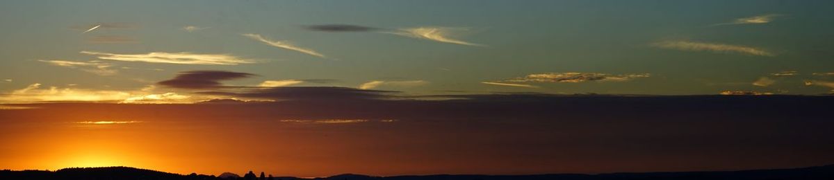 Silhouette of landscape against cloudy sky