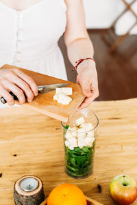 Midsection of woman preparing food on cutting board