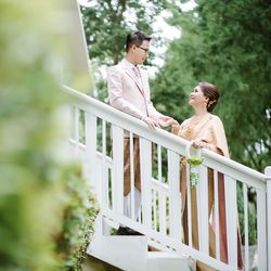 Woman standing on railing against plants