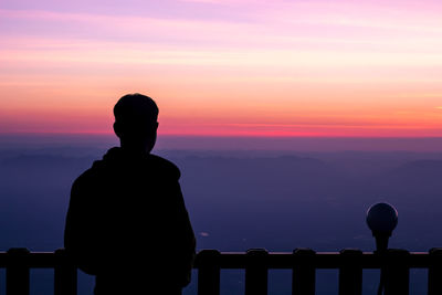 Silhouette man standing against sky during sunset