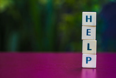 Close-up of toy blocks stack forming help text on table