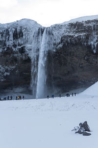 People on mountain against sky during winter