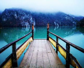 Jetty on lake against sky