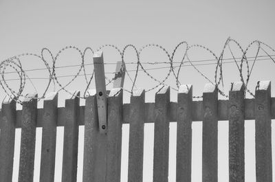 Barbed wire fence against clear sky