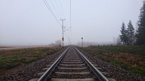 Railroad track amidst trees against clear sky