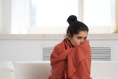 Young woman sitting on sofa at home