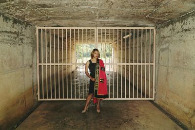 Full length portrait of woman standing in corridor