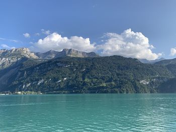 Scenic view of sea by mountains against sky