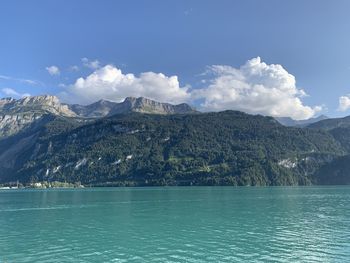 Scenic view of sea by mountains against sky