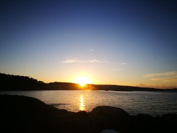 Scenic view of sea against clear sky during sunset