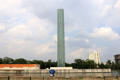 People on building against cloudy sky