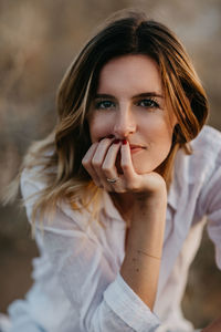 Portrait of woman with hand on chin at beach