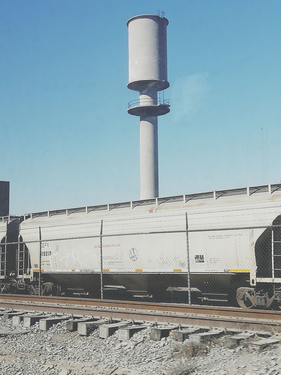 built structure, day, sky, clear sky, architecture, no people, rail transportation, building exterior, blue, nature, outdoors, track, copy space, railroad track, transportation, metal, sunlight, public transportation, street, wall - building feature