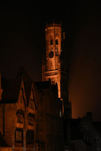 Low angle view of clock tower at night