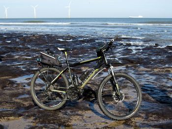 Bicycles on beach against sky