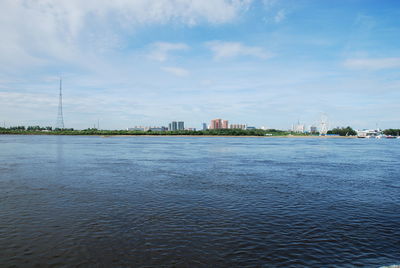 Scenic view of sea by buildings against sky