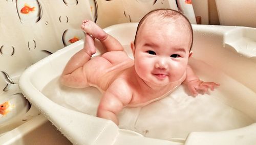 Portrait of baby girl in bathtub at bathroom