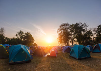 Tent on field against sky during sunset