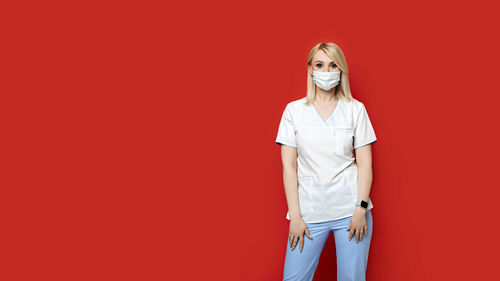 Portrait of a young woman against red background